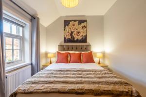 sypialnia z dużym łóżkiem z pomarańczowymi poduszkami w obiekcie Middlethorpe Manor - No 3 w mieście York