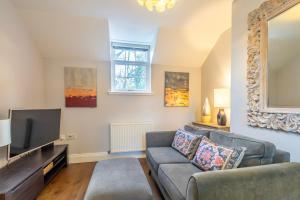 een woonkamer met een bank en een tv bij Middlethorpe Manor - No 3 in York