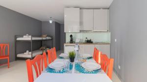 een eetkamer met een tafel en oranje stoelen bij Bridge D Luis II Apartment by Unique Hosts in Porto
