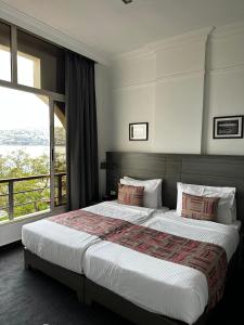 a bedroom with a large bed with a large window at Bel Azur Hotel - Resort in Jounieh