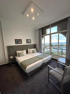 ein Schlafzimmer mit einem großen Bett und einem Stuhl in der Unterkunft Bel Azur Hotel - Resort in Jounieh