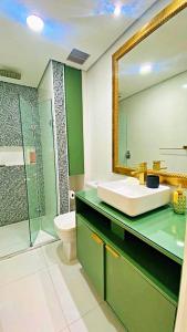 a bathroom with a sink and a toilet and a mirror at Apto cinematográfico vista mar in Guarujá +13 photos