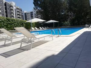 una piscina con sedie a sdraio e ombrelloni accanto a una piscina di Hotel Europa a Rende
