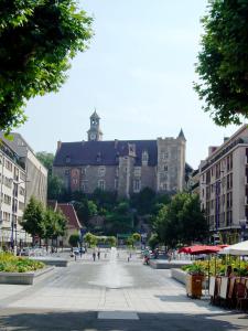 a large building with a clock tower in a city at Hotel Inn Design Montluçon in Montluçon