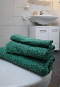 a stack of green towels sitting on a bathroom counter at Ferienwohnung Hüttennest in Villingen-Schwenningen