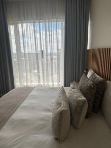 1 dormitorio con cama con almohadas y ventana grande en Sandton Serenity: UltimateGetaway 2, en Johannesburgo