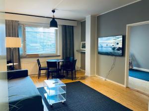 uma sala de estar com um sofá e uma mesa em STAY Kamppi Apartment em Helsinque