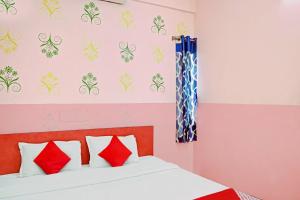 um quarto com uma cama com almofadas vermelhas e brancas em Flagship Star Guest House em Calcutá