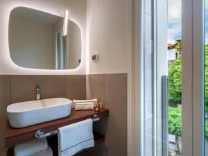 een badkamer met een wastafel en een spiegel bij Grand Hotel Majestic in Verbania