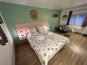 1 dormitorio con 1 cama y reloj en la pared en Domaine du Gros Chêne - terrasses avec jacuzzis privatifs, en Ablon