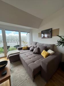 un soggiorno con divano marrone di fronte a una finestra di Modernes & stillvolles Apartment a Vienna