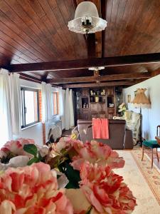 ein Wohnzimmer mit einem Sofa und einem Tisch mit Blumen in der Unterkunft Casa Da Noquinhas in Bunheiro