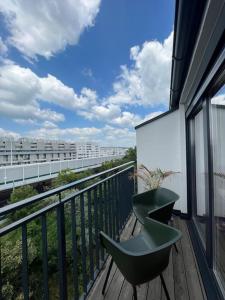 einen grünen Stuhl auf dem Balkon in der Unterkunft Modernes & stillvolles Apartment in Wien