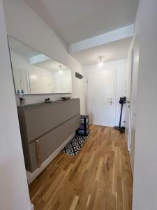 cocina con armarios blancos y suelo de madera dura en Modernes & stillvolles Apartment en Viena