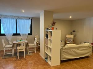 1 dormitorio con 1 cama, mesa y sillas en apartamento luanco playa, en Luanco