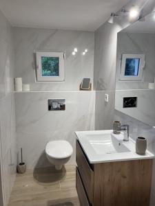 Baño blanco con aseo y lavamanos en villa vue mer cinq chambres Les terrasses des Collines en Le Cannet