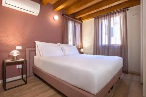 a bedroom with a large white bed and a window at Palazzina Riello in Venice