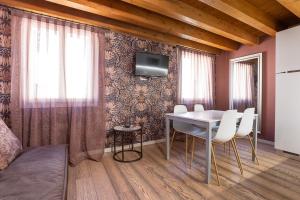a dining room with a table and a tv on a wall at Palazzina Riello in Venice