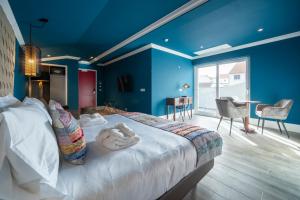 1 dormitorio con 1 cama grande y paredes azules en Açores Autêntico Boutique Hotel, en Angra do Heroísmo