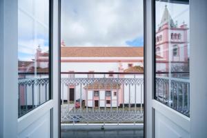 una ventana abierta con vistas a un edificio en Açores Autêntico Boutique Hotel en Angra do Heroísmo