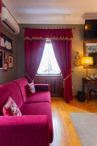sala de estar con sofá púrpura y ventana en Charming Antas House, en Oporto