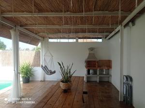 a living room with a wooden floor and a hanging hammock at Casa Pastor, Delta del Ebro in El Lligallo del Gànguil