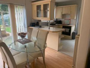 a kitchen with a glass table and a counter top at Stunning 3-Bed House in Cheadle in Cheadle