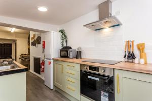 cocina con fregadero y nevera en Room 04 - Sandhaven Rooms Triple, en South Shields