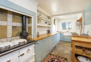 uma grande cozinha com armários azuis e um lavatório em Minster House - Group Hot Tub em York