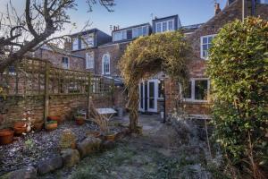 a brick house with an archway and potted plants at Minster House - Group Hot Tub in York