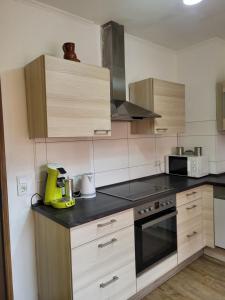 a kitchen with wooden cabinets and a yellow appliance on a counter at Gemeinschaft Ferienhaus in Bad Neuenahr-Ahrweiler +52 photos