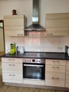 a kitchen with a stove top oven and wooden cabinets at Gemeinschaft Ferienhaus in Bad Neuenahr-Ahrweiler