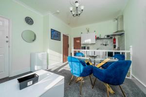 a dining room with blue chairs and a table at Uksas Stunning one bedroom Flat Free Parking in London