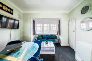 a living room with a blue couch and a table at Uksas Stunning one bedroom Flat Free Parking in London
