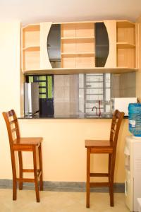 a kitchen with two wooden chairs and a counter at Lighthomes Two Bedroom Thika CBD in Thika