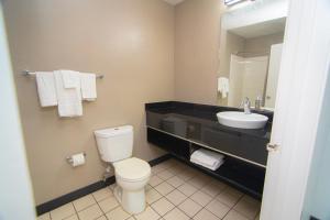 a bathroom with a toilet and a sink and a mirror at Studio 6-West Palm Beach, FL in West Palm Beach
