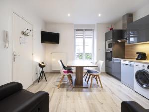 a kitchen and living room with a table and chairs at Residence Louis Quartier Gare in Vittel