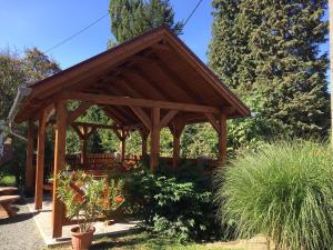 a wooden pavilion in a garden with plants at Hubertus Vendégház in Parád