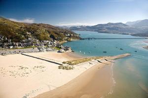 an aerial view of a beach with people in the water at Aelfor Cottage in Barmouth in Barmouth