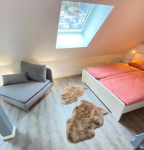 ein Schlafzimmer mit einem Bett und einem Sofa und eine Katze auf dem Boden in der Unterkunft Ruhige, Neue Dachwohnung an Altstadt, Nahe Messe in St. Gallen