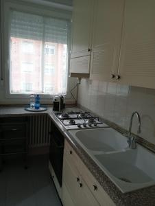 a kitchen with a stove and a sink and a window at Residenza Camilla in Vicenza