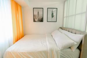 a bed in a bedroom with two pictures on the wall at Frost at Air Residences Makati in Manila