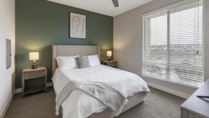 - une chambre avec un lit et 2 tables de nuit avec des lampes dans l'établissement Landing Modern Apartment with Amazing Amenities (ID5374X57), à San Diego