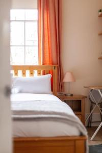 1 dormitorio con 1 cama, ventana y mesa en Spacious & Central 3-bed flat by popular Waterloo! en Londres