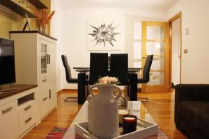 a living room with a couch and a table with chairs at Apartamento Centro de Pontevedra in Pontevedra