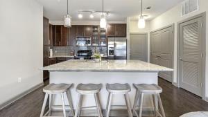 a kitchen with a large island with bar stools at Landing Modern Apartment with Amazing Amenities (ID1721X12) in Fort Worth