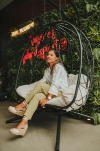 a woman is sitting in a swing at Hotel Málaga Nostrum Airport in Málaga