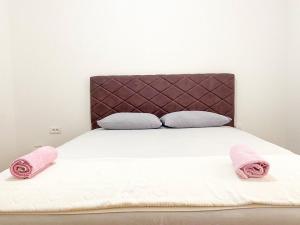 ein Bett mit zwei rosa Handtüchern darüber in der Unterkunft Silver Apartment with private garage in Bar