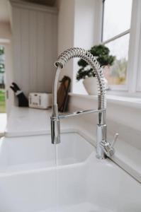 a kitchen sink with a faucet in a kitchen at Woodhaven Stays in Scredington