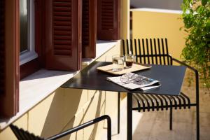 a black table and chair with a plate and glasses at Vrachos Athens Suites in Athens
